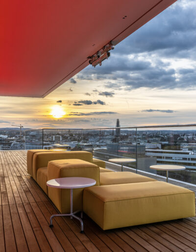 Die Aussicht des B1 Rooftop Bistro bei Sonnenuntergang. Rote Beleuchtung des Lichtdesigners James Turrell und einer wunderschönen Panorama-Aussicht über Basel.