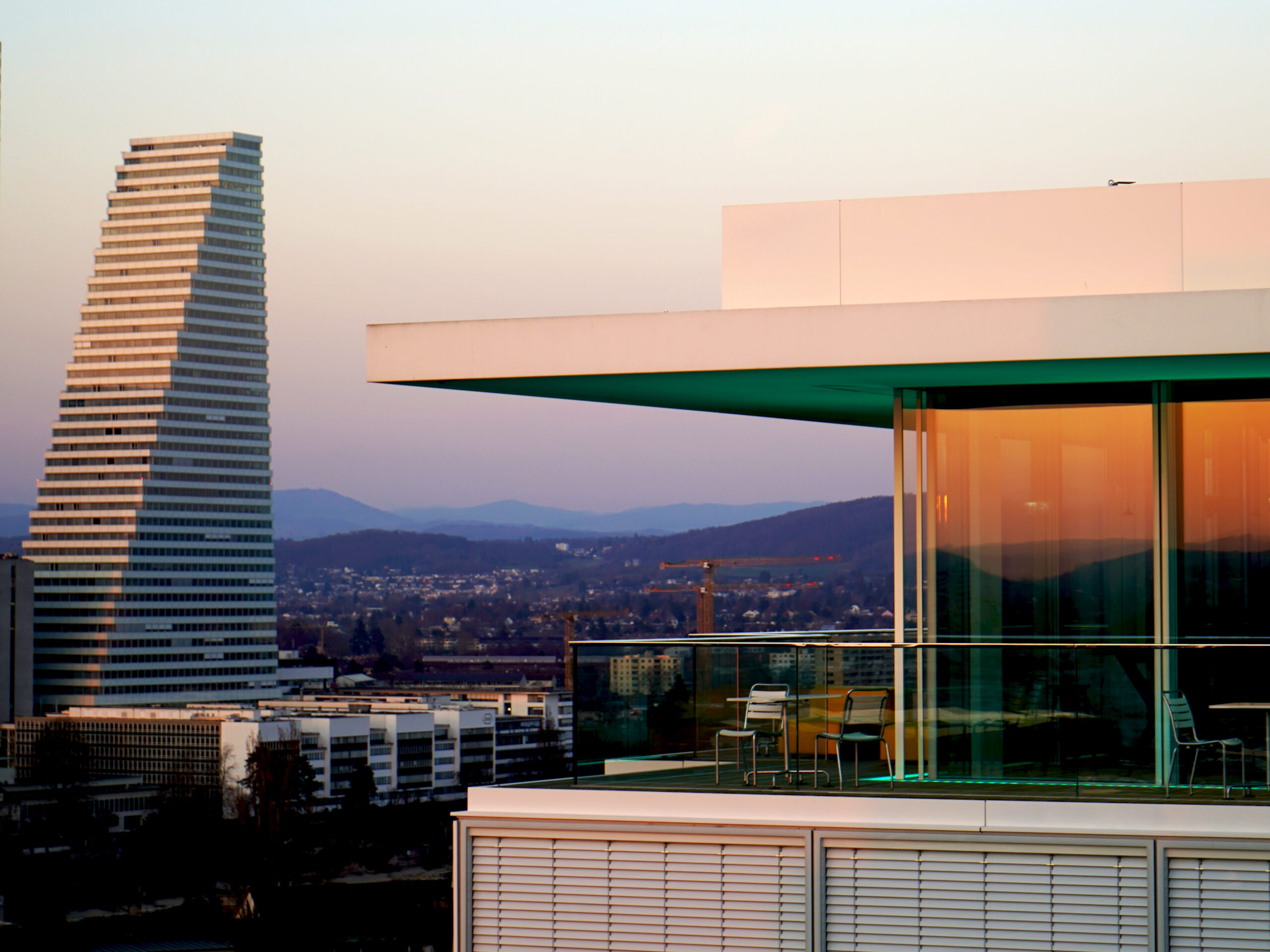 Die Inneneinrichtung und Bar des B1 Rooftop Bistro. Gäste bewegen sich von der Terrasse ins Bistro.